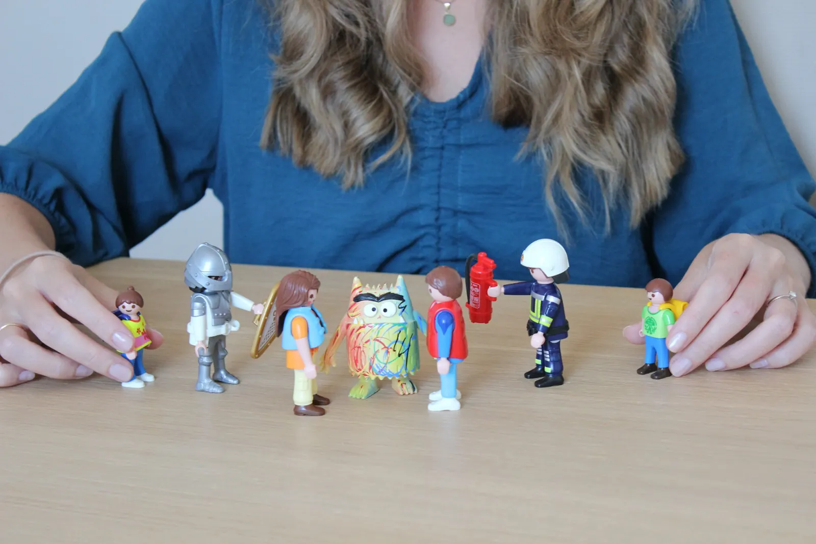 Manos colocando figuras sobre la mesa para representar las partes de cada persona