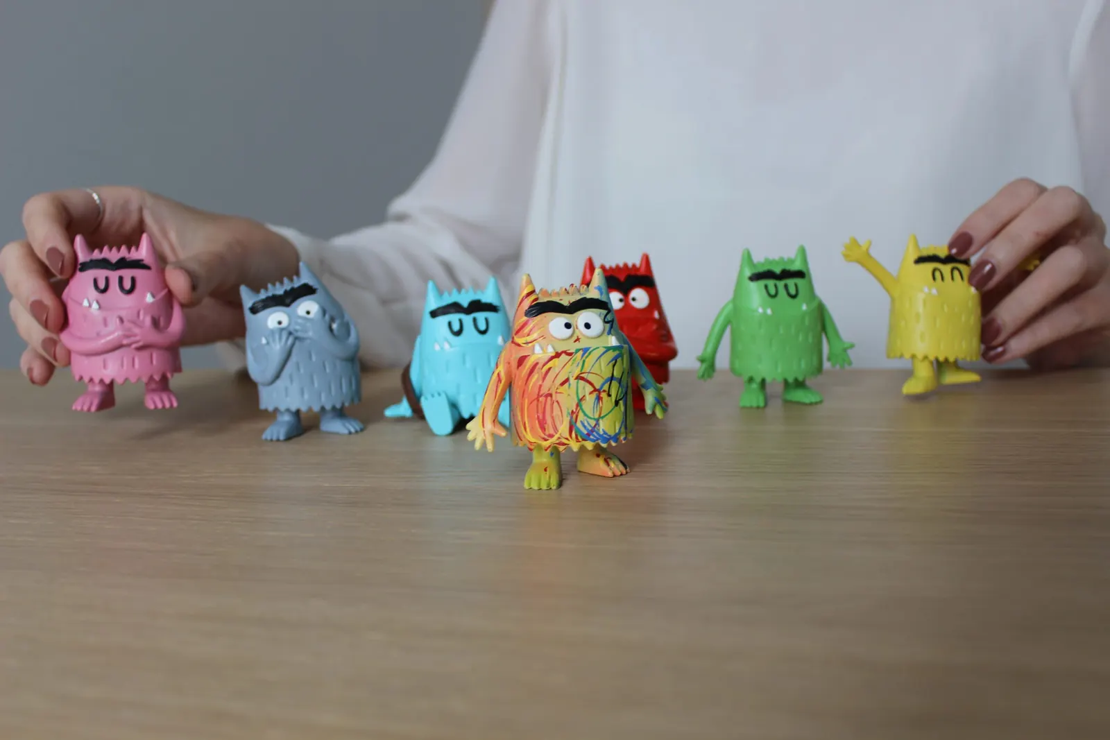 Figuras de monstruos de colores en fila sobre una mesa